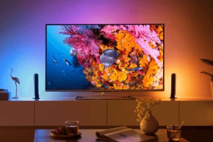 Man sieht einen Fernseher mit Ambilight Effekt.